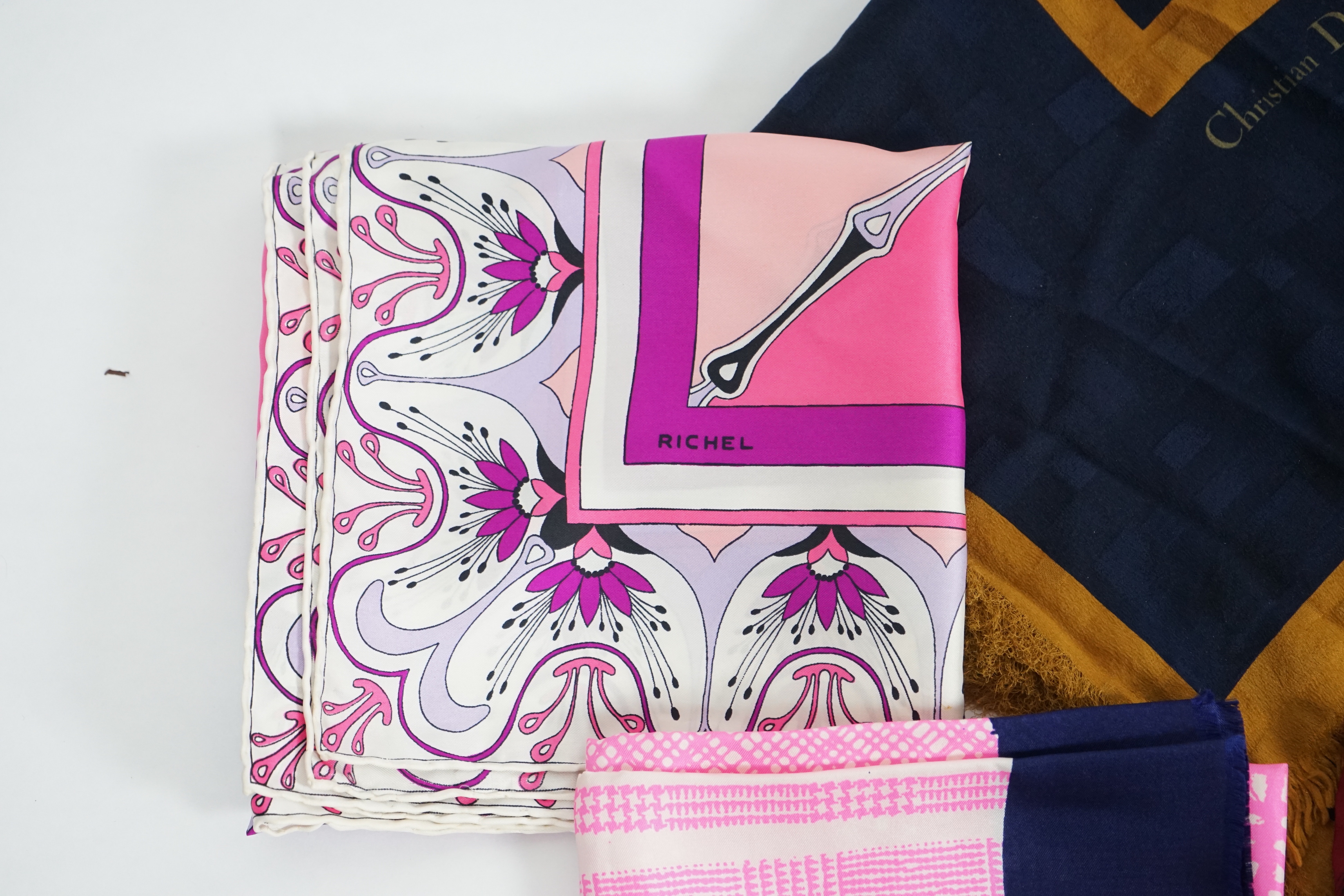 A selection of Yves Saint Laurent, two Christian Dior, Richel and Loewe silk scarves, YSL, 83cm x 85cm Christian Dior: 84cm x 80cm Richel: 87cm x 87cm Loewe: 86cm x 82cm Christian Dior large scarf 120cm x 130cm approx.